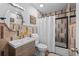 Bathroom featuring modern vanity, decorative tile, and a shower and tub with a curtain at 3351 S Field St # 104, Lakewood, CO 80227