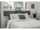 Up-close bedroom view with hardwood floors, a grey padded headboard, and a bright window with neighborhood views at 3351 S Field St # 104, Lakewood, CO 80227