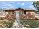 Charming brick home featuring a well-manicured lawn and a welcoming front entrance with a white door and wreath at 3351 S Field St # 104, Lakewood, CO 80227