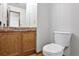Bathroom featuring a toilet, vanity with wood cabinets and brick backsplash, and light hardwood floors at 9669 Jellison Way, Broomfield, CO 80021