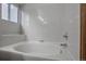 Bright bathroom featuring a bathtub with white tile surround, a window, and a chrome showerhead at 9669 Jellison Way, Broomfield, CO 80021