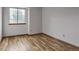 Bright bedroom featuring hardwood floors, a window, and white walls for a clean, modern look at 9669 Jellison Way, Broomfield, CO 80021