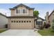 Charming two-story home featuring tan siding, brick accents, and an attached two car garage at 9669 Jellison Way, Broomfield, CO 80021