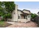 Exterior shot showing the back of the home, a stone patio, and mature trees at 9669 Jellison Way, Broomfield, CO 80021