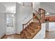 Hardwood curved staircase leading to the second floor, adjacent to the kitchen at 9669 Jellison Way, Broomfield, CO 80021