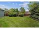 Lush backyard featuring privacy fence, mature trees, and manicured green grass lawn at 8625 W Dartmouth Pl, Lakewood, CO 80227