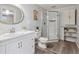 Stylish bathroom with updated vanity, glass shower, and a round decorative mirror at 8625 W Dartmouth Pl, Lakewood, CO 80227