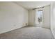Empty bedroom with neutral carpet, bare walls, and a window with sheer curtains at 8625 W Dartmouth Pl, Lakewood, CO 80227