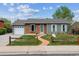 Charming single-story home with brick accents, a curved walkway, and a well-manicured front yard at 8625 W Dartmouth Pl, Lakewood, CO 80227