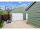 View of the detached garage and driveway featuring a basketball hoop near fenced yard at 8625 W Dartmouth Pl, Lakewood, CO 80227