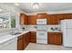 Bright kitchen featuring quartz countertops, white appliances, and updated cabinetry at 8625 W Dartmouth Pl, Lakewood, CO 80227