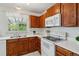 Bright kitchen features stainless steel sink, white countertops, and wooden cabinets with appliances at 8625 W Dartmouth Pl, Lakewood, CO 80227