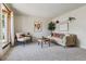 Bright living room with carpet, modern decor, and a large window for natural light at 8625 W Dartmouth Pl, Lakewood, CO 80227