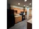 Kitchen with orange cabinets, black appliances, and laminate flooring at 440 Empire St, Aurora, CO 80010