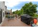 Enjoy outdoor dining on this back deck, complete with a grill and seating, surrounded by lush greenery at 14261 W Evans Cir, Lakewood, CO 80228