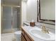 Well-lit bathroom featuring a vanity, toilet, and a shower with a glass door at 14261 W Evans Cir, Lakewood, CO 80228