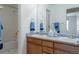 Well-lit bathroom featuring dual sinks, wood cabinets and a shower-tub combo at 14261 W Evans Cir, Lakewood, CO 80228