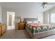 Spacious main bedroom with a comfortable bed, carpet, and adjacent bathroom at 14261 W Evans Cir, Lakewood, CO 80228