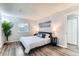 Bright bedroom with modern decor, wood floors and large window creates a serene atmosphere at 10211 Ura Ln # 1-308, Thornton, CO 80260