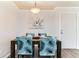 Dining area features a wood table with seating for four and modern floral print chairs at 10211 Ura Ln # 1-308, Thornton, CO 80260
