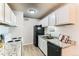 Charming kitchen featuring white cabinets, sleek black appliances, and modern countertops at 10211 Ura Ln # 1-308, Thornton, CO 80260