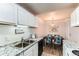 Kitchen seamlessly flows to the dining area, featuring white cabinets, stone countertops, and sleek appliances at 10211 Ura Ln # 1-308, Thornton, CO 80260