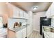 A well-lit kitchen is updated with white cabinets, stone counters, and modern appliances at 10211 Ura Ln # 1-308, Thornton, CO 80260