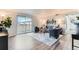 Bright living room boasts a sliding glass door to the patio, neutral colors and wood-look flooring at 10211 Ura Ln # 1-308, Thornton, CO 80260