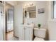 Well-lit bathroom featuring a classic vanity, updated fixtures, and a framed mirror with decorative sconce lighting at 2281 Florence St, Aurora, CO 80010