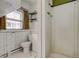 A compact bathroom with a walk-in shower, toilet, and natural light from a window at 2281 Florence St, Aurora, CO 80010