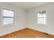 Bright bedroom featuring gleaming hardwood floors, fresh paint, and two windows for ample natural light at 2281 Florence St, Aurora, CO 80010