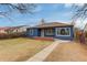 Quaint single-story blue home with a cozy brick porch and mature trees in a quiet neighborhood at 2281 Florence St, Aurora, CO 80010