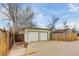 Two-car garage with a spacious driveway and a weathered wooden fence at 2281 Florence St, Aurora, CO 80010