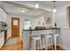 Modern kitchen with breakfast bar, white cabinets, and an exterior door to the backyard at 2281 Florence St, Aurora, CO 80010