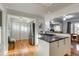 Bright kitchen featuring stainless steel appliances, white cabinetry, island with cooktop, and hardwood floors at 2281 Florence St, Aurora, CO 80010