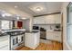 Modern kitchen with stainless steel appliances, farm sink, white cabinets, and peninsula with cooktop at 2281 Florence St, Aurora, CO 80010