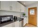 Modern kitchen with white cabinets, stylish countertops, and stainless steel appliances near wooden door at 2281 Florence St, Aurora, CO 80010