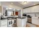 Updated kitchen featuring stainless steel appliances, a breakfast bar, and seamless living room access at 2281 Florence St, Aurora, CO 80010