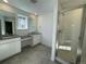 Modern bathroom with double sinks, white cabinetry, and a glass-enclosed shower at 545 Twilight St, Erie, CO 80516