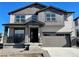 Charming two-story home with a gray color scheme, stone accents, and a covered front porch at 545 Twilight St, Erie, CO 80516