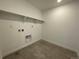 Compact laundry room with tile flooring and shelving for storage at 545 Twilight St, Erie, CO 80516