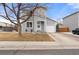 Charming gray two-story home featuring a well-manicured front yard, attached garage, and inviting entryway at 1212 Magpie Ave, Brighton, CO 80601