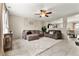 Inviting living room with neutral tones, comfortable furniture, a ceiling fan, and large windows for natural light at 1212 Magpie Ave, Brighton, CO 80601