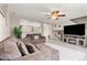 Comfortable living room with ample seating, a ceiling fan, open layout, and a view into the dining area at 1212 Magpie Ave, Brighton, CO 80601