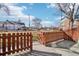 Cozy fenced backyard with partial view of neighborhood buildings and mature trees on a sunny day at 2805 Jasmine St, Denver, CO 80207