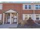 Charming red brick townhouse featuring a covered front porch and well-maintained landscaping at 2805 Jasmine St, Denver, CO 80207