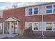 Red brick townhouse featuring symmetrical windows, white shutters, and a covered entry porch at 2805 Jasmine St, Denver, CO 80207