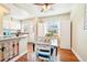 Bright eat-in kitchen boasts wood floors, white cabinetry and natural light from large windows at 2805 Jasmine St, Denver, CO 80207