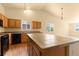 Bright kitchen featuring a tile breakfast bar, hardwood floors, and natural light at 6760 E 129Th Ave, Thornton, CO 80602
