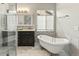 Elegant bathroom with a free-standing tub, glass shower, and a vanity with a dark wood finish at 5140 Mt Pawnee Ave, Frederick, CO 80504